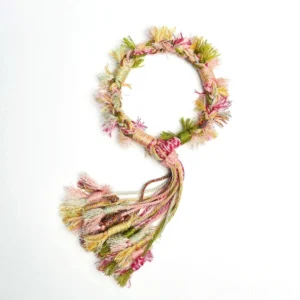 Handwoven pastel Chinese bracelet shown from above with circular braided cord structure frayed trim and colourful knotted tassel