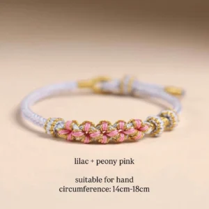 Lilac and peony pink handwoven peony Chinese knot bracelet with gold-tone accents on a warm beige background