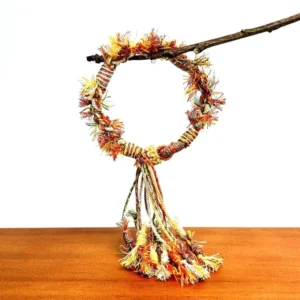 Front view of a handwoven Tibetan knot Chinese bracelet with vibrant braided rope, fluffy frayed ends, and bundled multicolour tassel decoration