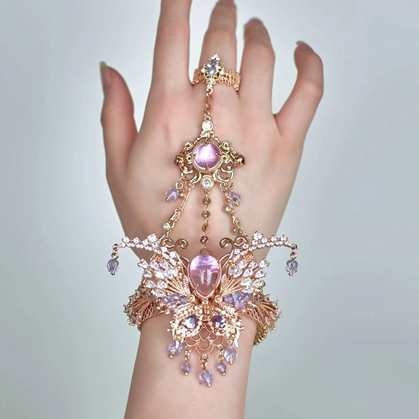 Hanfu hand and wrist jewelry with rose-gold-tone metal, a large central purple gemstone, connected ring and bracelet design, and crystal tassel decorations