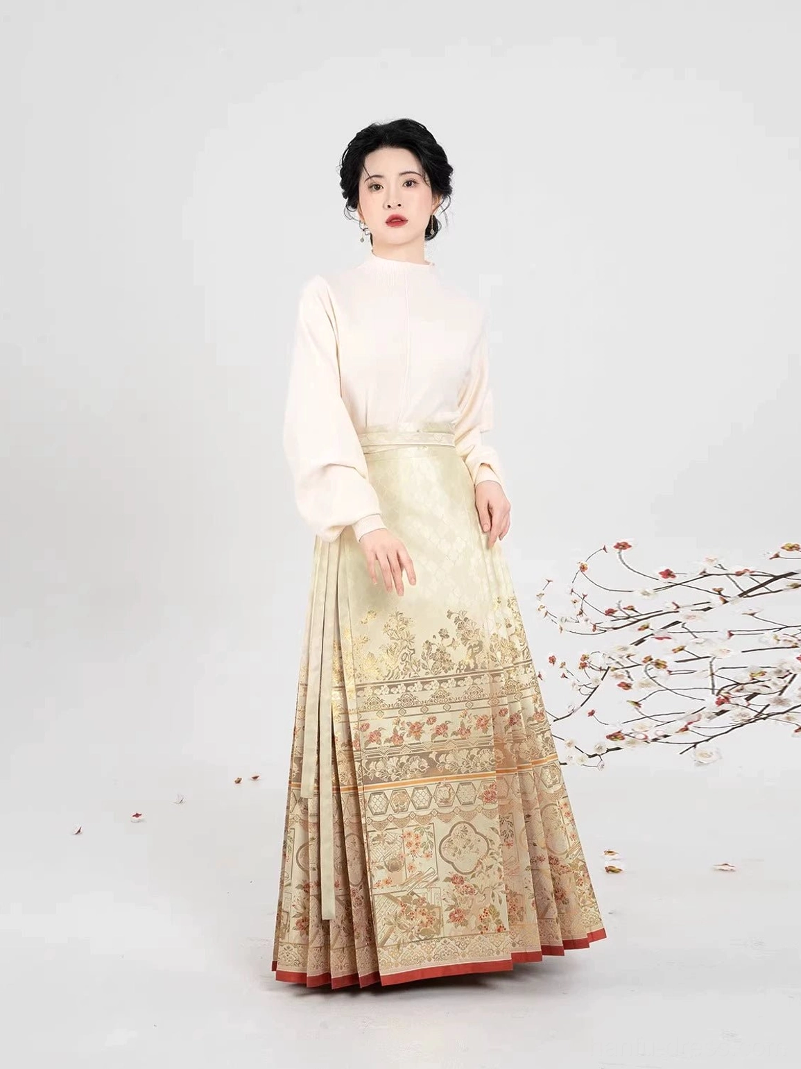 Front view of an off-white cross-collar hanfu inner top styled with a gold jacquard mamian skirt and red hem