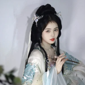 Model wearing a light cyan white hanfu outfit with a traditional coiled hairstyle decorated with a crescent butterfly Chinese hair pin
