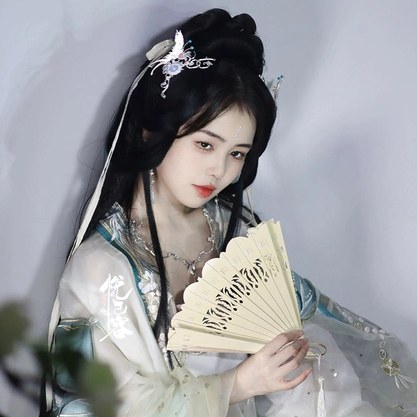 Hanfu portrait showing delicate butterfly hair accessories styled with a light cyan white outfit and a vintage Chinese folding fan