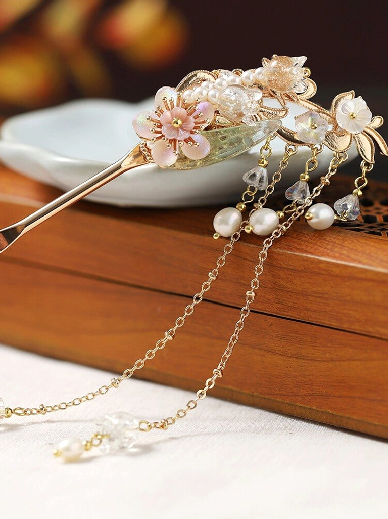 Hanfu tassel hair stick displayed on a wooden tray with floral ornaments, glazed leaves, pearl crystals, and long flowing tassels