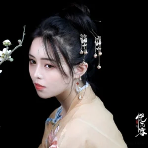 Hanfu woman wearing an elegant traditional Chinese hairpin with pearl ornaments and bell tassels in an ancient bun hairstyle