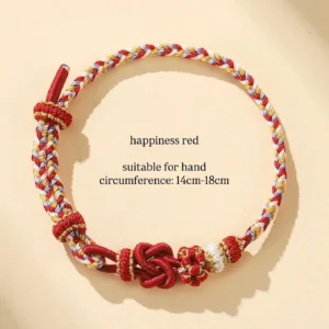 Happiness red Chinese knot handwoven bracelet with multicolor braided cord, white round bead, and red gold-tone spacer beads on a light beige background