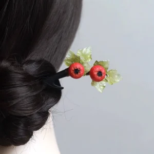Hawthorn fruit Chinese hair stick displayed in a traditional coiled Hanfu hairstyle with two red berries and layered light green leaves
