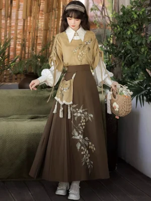 Back three-quarter view of the hazelnut milk tea modern Hanfu outfit showing embroidered vest and skirt details, layered white blouse, and coordinated traditional-inspired styling