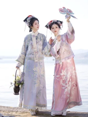 Side view of coordinated Qing Dynasty Manchu-inspired women clothing beside a lakeside with floral patterns and elegant long silhouettes