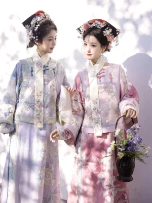 Front full-body view of two women wearing pastel Qing Dynasty Manchu traditional costumes with floral prints, embroidered details, and traditional hairstyles