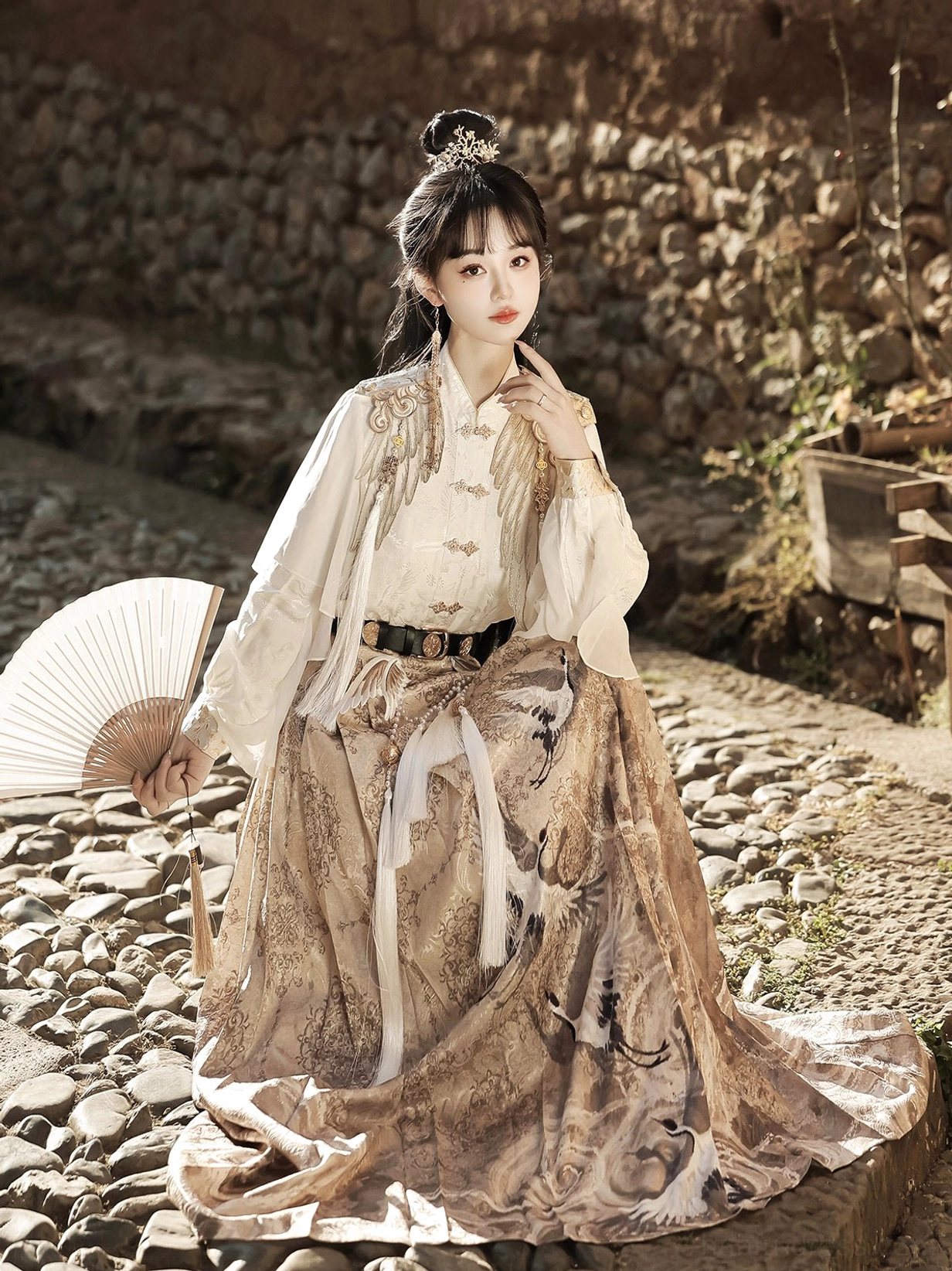 Seated model wearing Heavenly Envoy Chinese Hanfu with flowing khaki horse face skirt, white embroidered lantern sleeve top, traditional hairstyle, and hair ornament