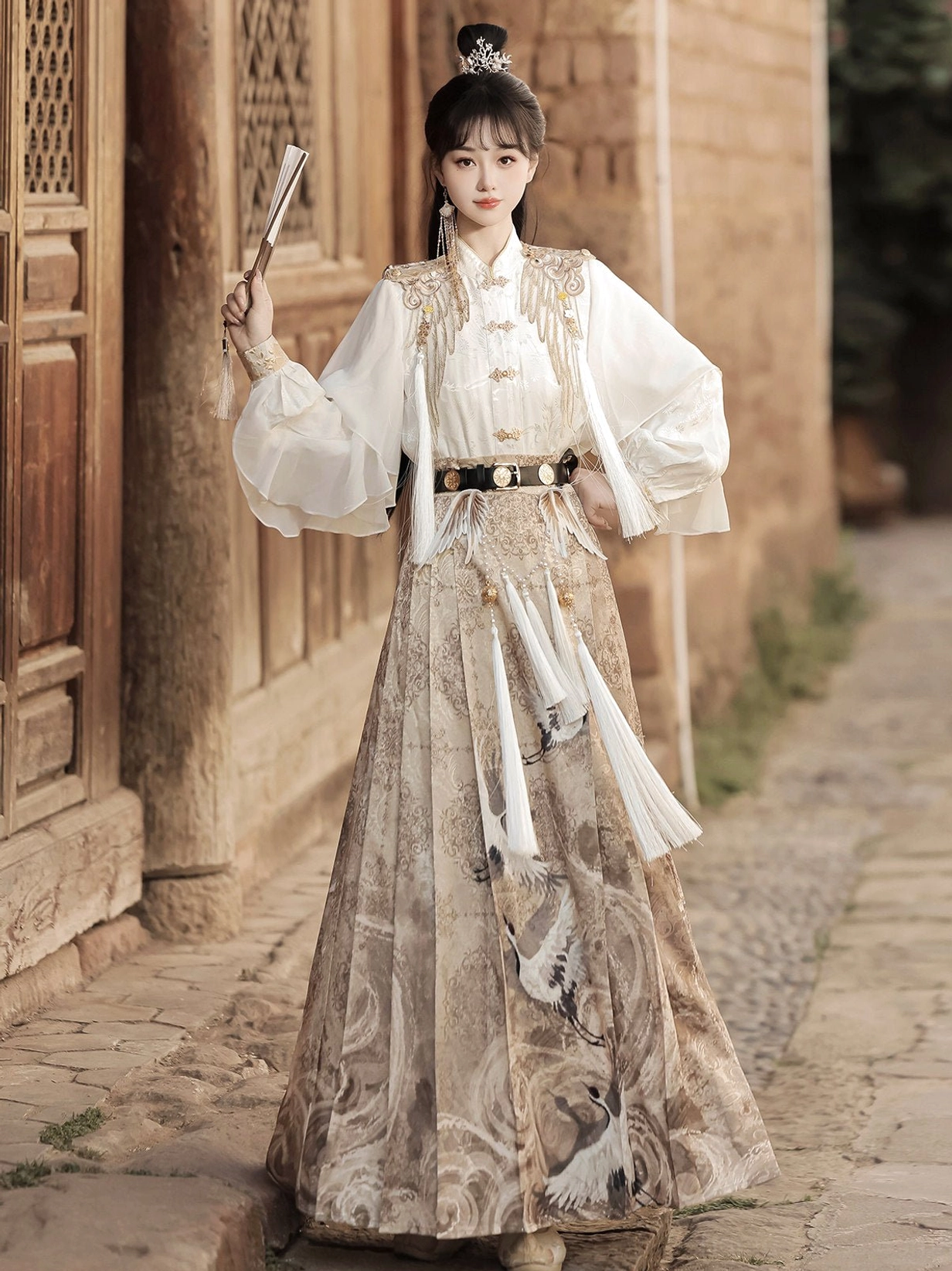Front three quarter view of modern Chinese Hanfu Heavenly Envoy full set with white blouse, khaki mamianqun, waist tassel, and ancient architectural styling