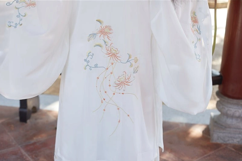 Close-up of white Song Dynasty Hanfu beizi coat with light blue and gold chrysanthemum vine floral embroidery