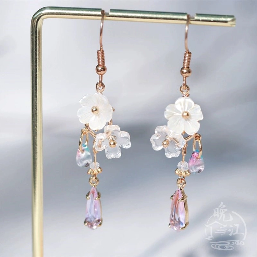 Close frontal view of Hua Luo Hanfu floral dangle earrings with white flower charms, crystal clusters, and purple gradient drops