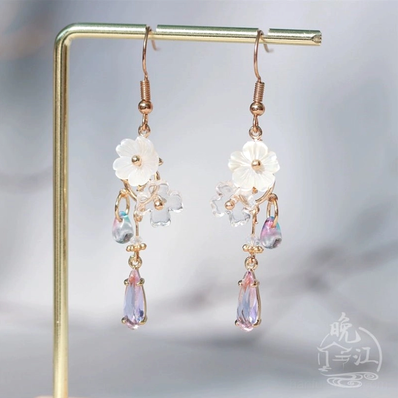 Elegant Hua Luo Hanfu jewelry earrings on a display rack featuring white floral decorations and lavender crystal drop details