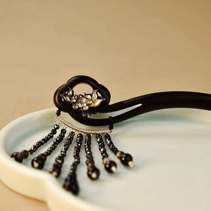 Traditional Chinese tassel hairpin displayed on white cloud ceramic tray with dark wood hair stick and black beads
