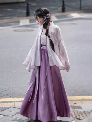 Back three-quarter view of a wisteria themed Song Dynasty Hanfu outfit with a sheer lavender cardigan, flowing purple skirt, long waist ribbons, and floral hairpin