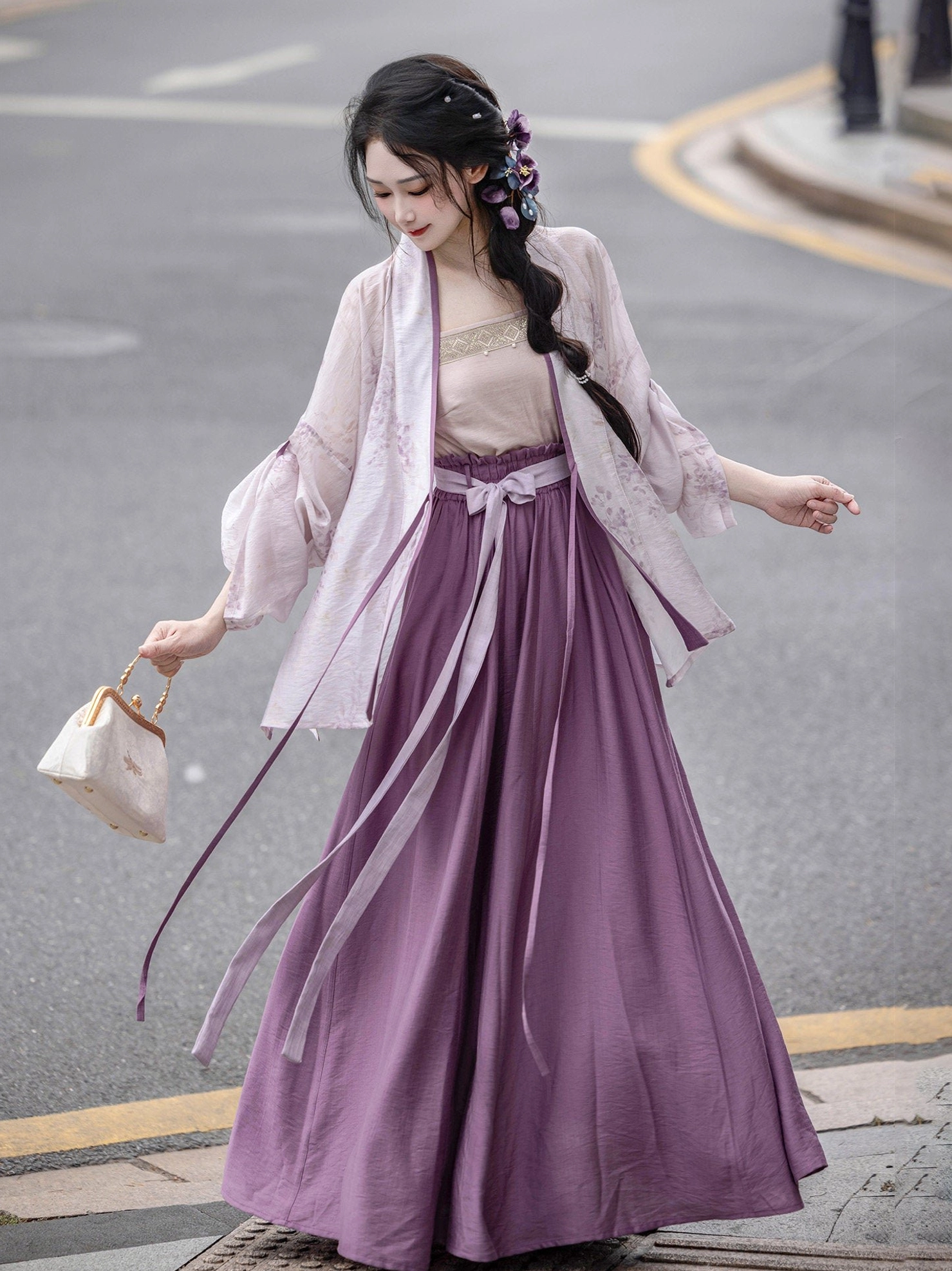 Ice Wisteria Song Dynasty modern Hanfu set styled on a city street with a sheer purple floral cardigan, nude camisole, deep purple long skirt, and beige handbag