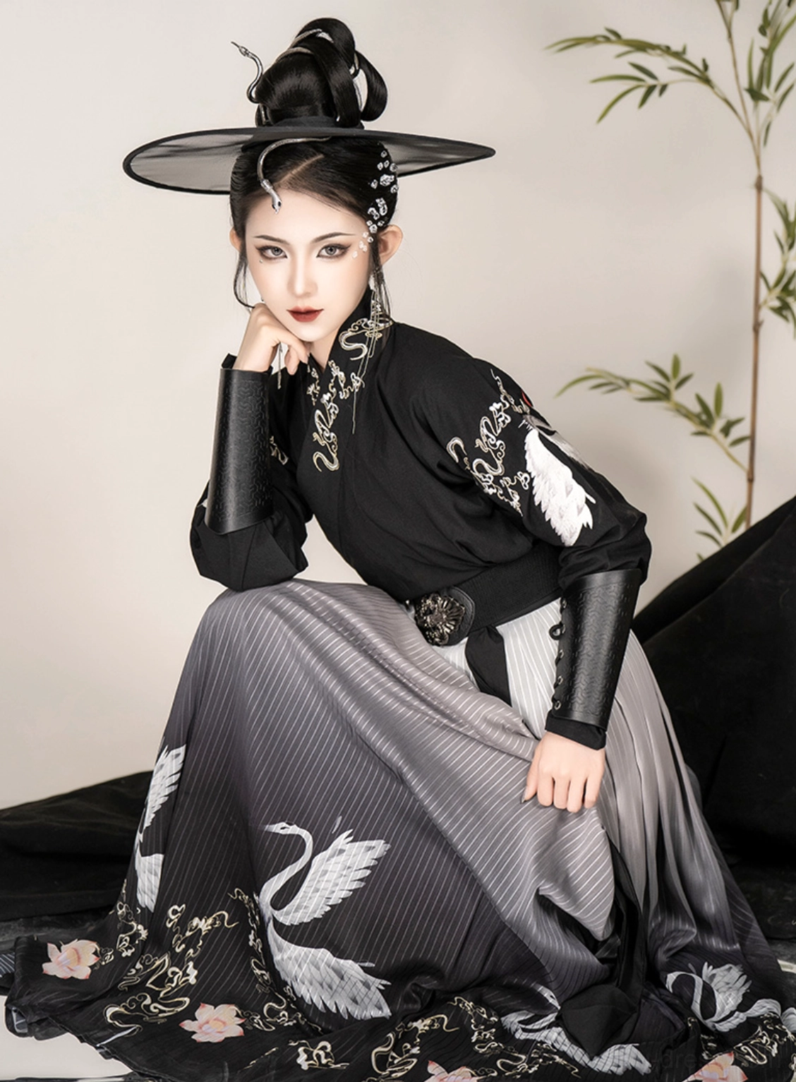 Close side view of black immortal crane Hanfu showing cross-collar top, silver crane embroidery and gradient pleated qiyao skirt