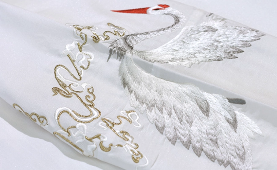 Detailed red-crested immortal crane embroidery with gold cloud stitching on wuxia style Hanfu fabric
