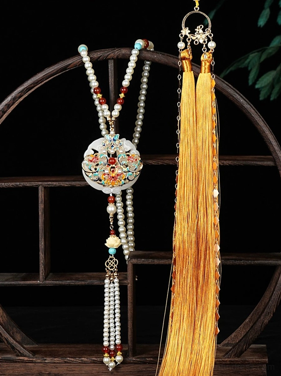 Imperial Chinese yingluo necklace displayed on a wooden shelf with layered pearl bead chains, white floral pendant and long golden silk tassels