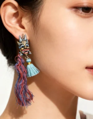Chinese imperial lion mask tassel hook earrings worn on ear, featuring hand-painted folk lion charm with red blue and cyan tassels