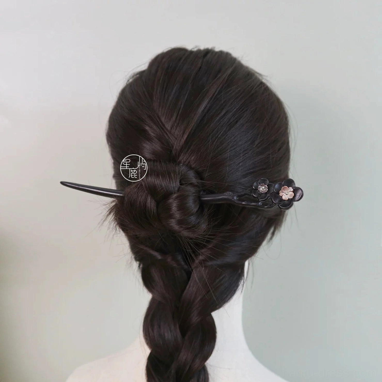 Back view of an elegant braided hairstyle styled with a slim dark wooden plum blossom Chinese hair stick for Hanfu fashion