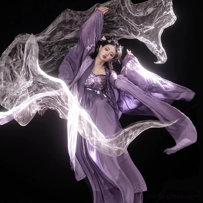 Low-angle dynamic view of the Iris Butterfly purple Hanfu Heziqun set with dramatic wide sleeves, embroidered details, flowing skirt, and elegant dance-inspired pose
