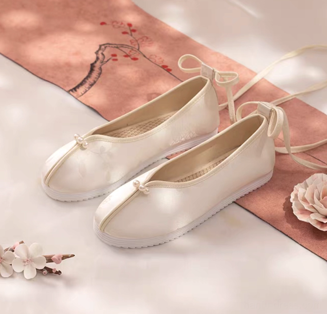 Ivory pearl traditional Chinese Hanfu shoes for women with subtle floral textured upper, apricot trim, back tie straps, and white rubber soles