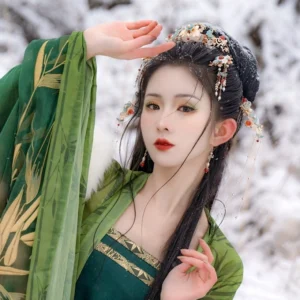 Traditional Chinese Hanfu hair crown and matching side hair ornaments styled on model wearing green Hanfu in snow