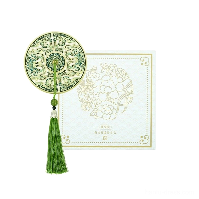 Jade green Chinese pocket mirror with gold-toned frame, traditional enamel-style patterns, matching green tassel, and jade-like accents beside a floral gift card
