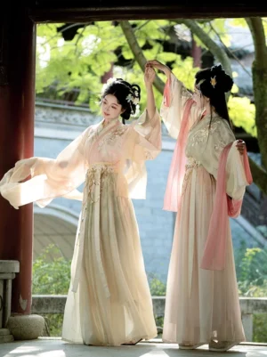 Jin-style Qiyao Ruqun Hanfu side view with two models dancing under a traditional wooden archway in soft beige and pink gradient colors with floral details and flowing sleeves