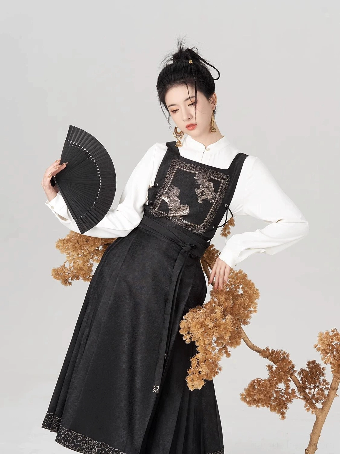 Jinwu black and gold Ming Dynasty Hanfu mamianqun outfit with Golden Crow embroidery and black folding fan