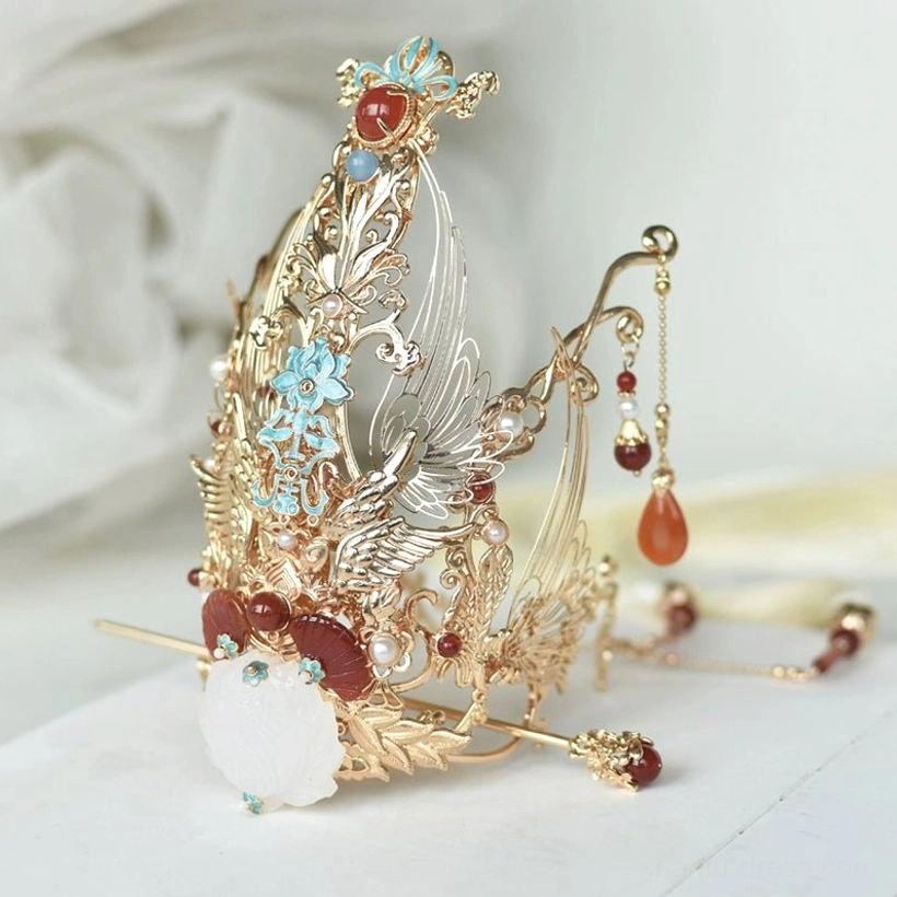Side view of ornate Jiugao Chinese hair crown with gold filigree frame blue enamel-style flowers red agate-style details white pendants hairpin and tassels