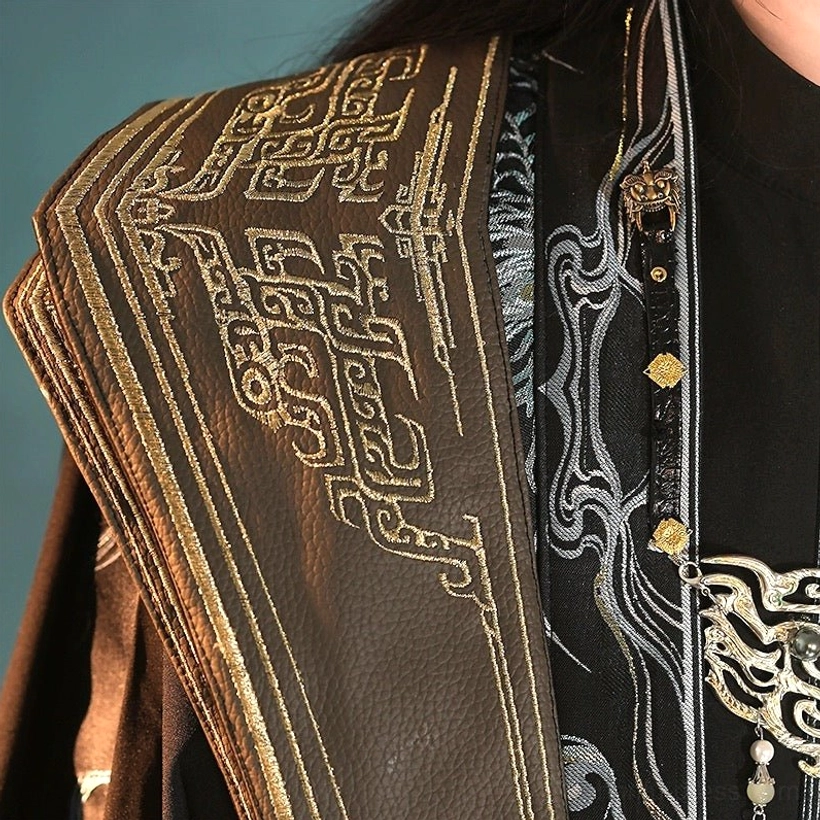 Close-up of King Lanling fantasy Hanfu shoulder panel with gold geometric embroidery, silver wave motifs and decorative buttons