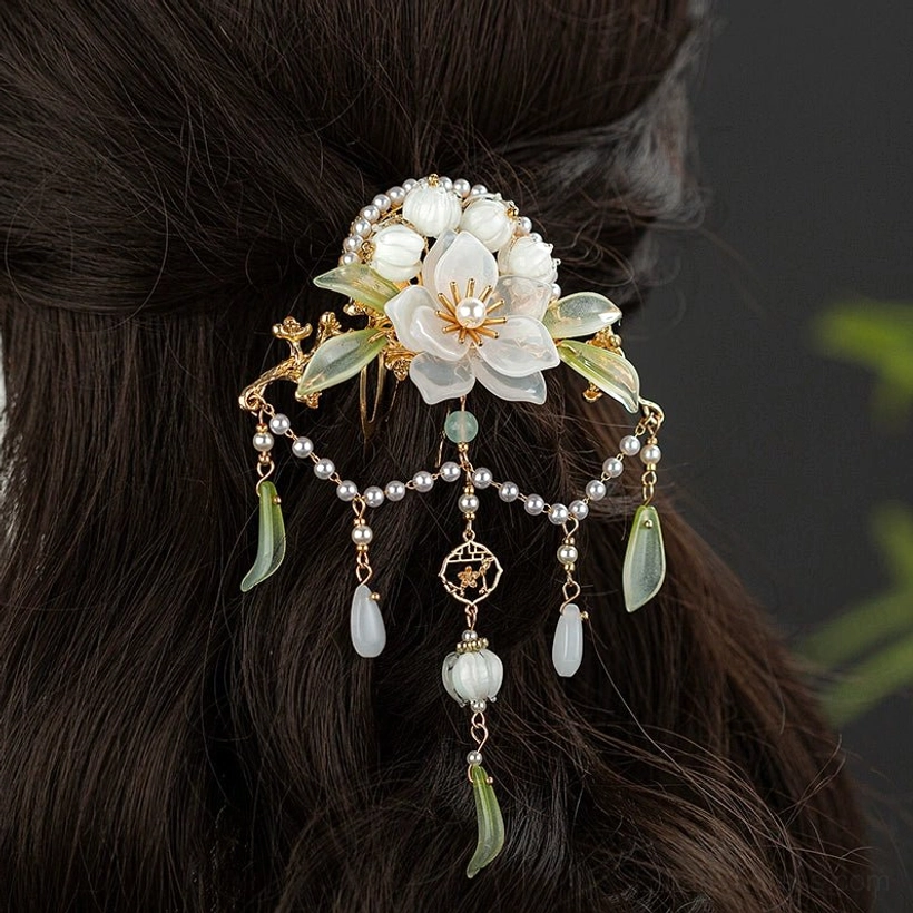 Lanling camellia pearl tassel Hanfu back hair pin worn on a dark brown updo, featuring white flowers, jade green leaves, gold tone metalwork and dangling pendants