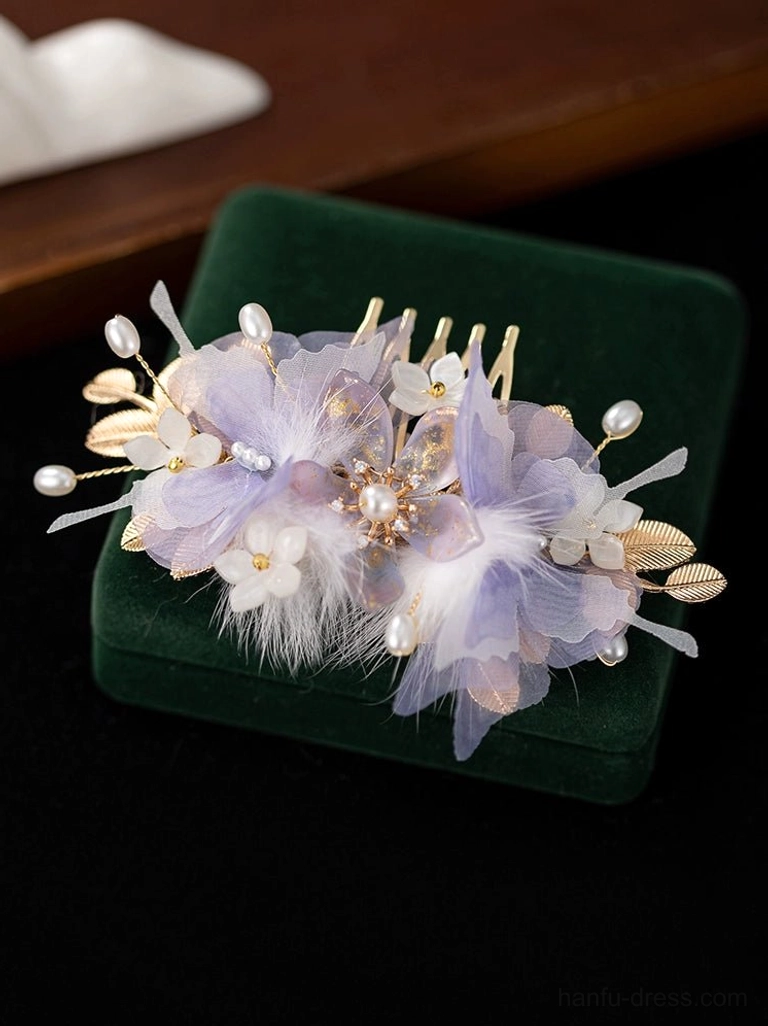 Lavender flower Hanfu hair comb with white feather accents, faux pearls and gold-tone leaf ornaments on green velvet display