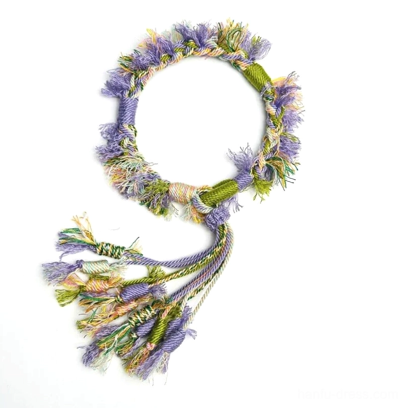 Lavender handwoven Tibetan-inspired knot bracelet with purple green yellow cream threads and multicolor tassel on white background