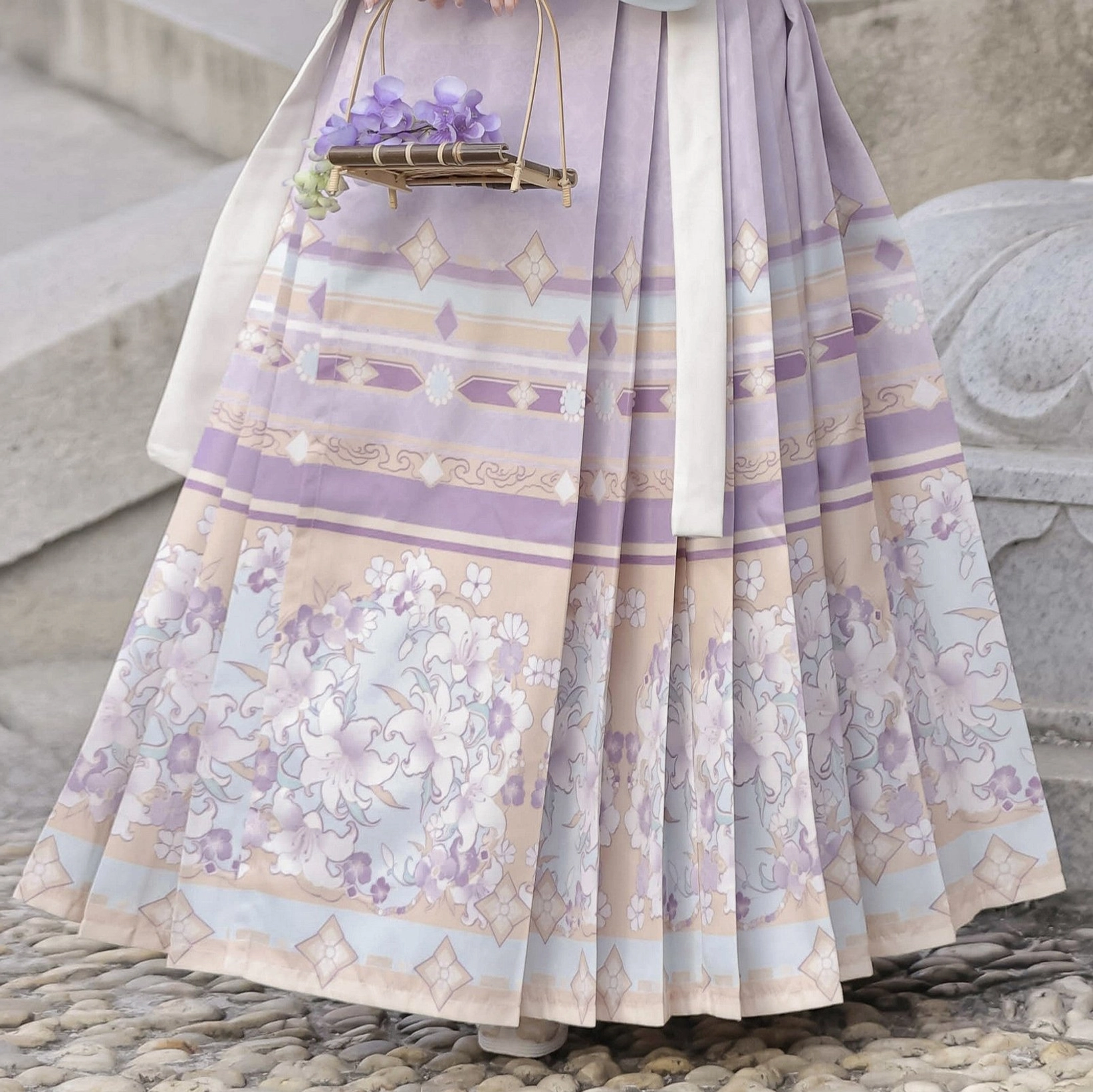 Close-up of lavender Ming Dynasty Mamian skirt with pleated construction, floral geometric print, and layered border details