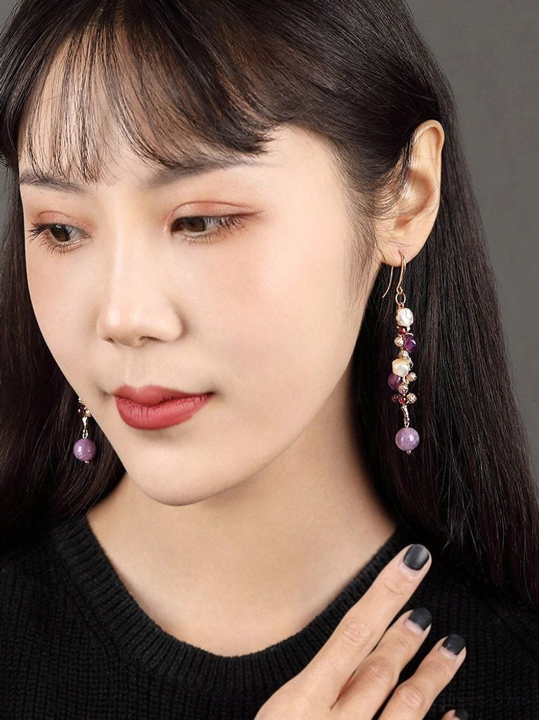Model wearing lavender pearl drop Chinese earrings with purple gemstone-style beads and gold-tone hook ear wires