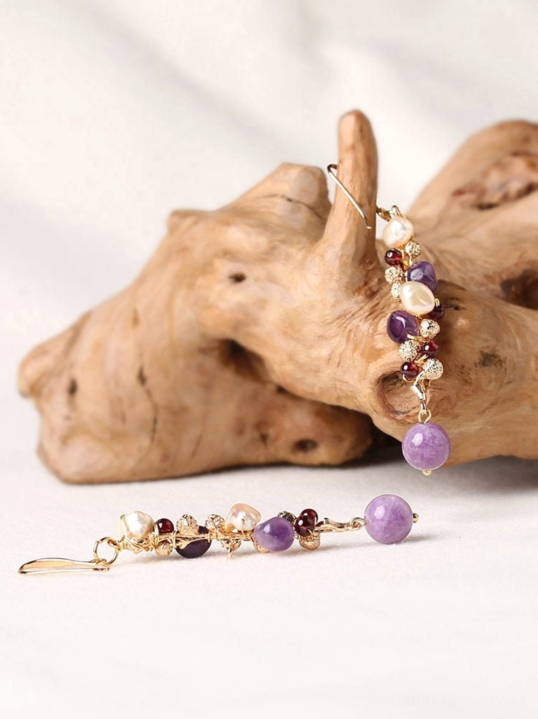 Pair of lavender pearl drop earrings displayed on white fabric and driftwood showing the full dangling Chinese jewelry design