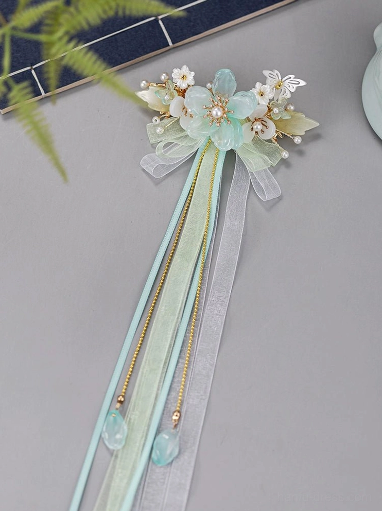 Left side close-up view of mint green antique Hanfu hairpin displaying layered ribbon tassels floral decorations pearl accents and Chinese inspired details