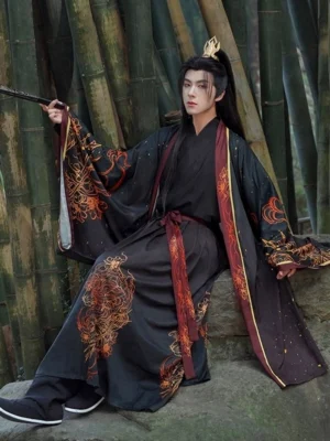 Male model wearing a complete Leo-inspired Wei-Jin Wuxia Hanfu set in black, red, and gold while seated on a stone in a bamboo grove, showing wide sleeves, flame-inspired decoration, and a red waist sash