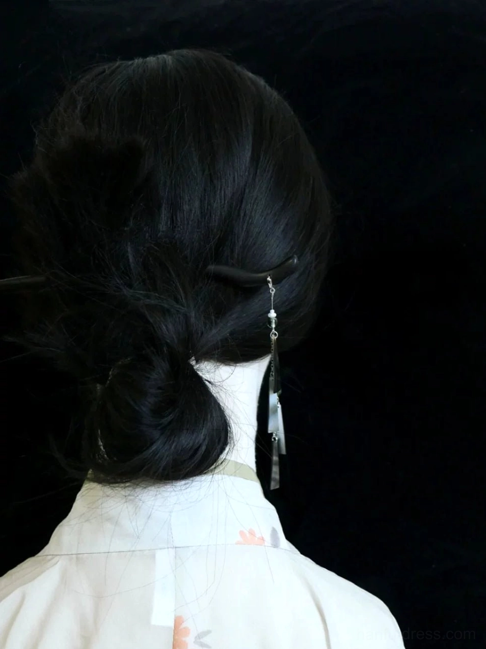 Woman wearing Letter from the Wind long green tassel Chinese earrings with a low bun and floral Hanfu outfit