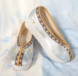 Light cyan embroidered Chinese Hanfu platform shoes with pearl bow ornament, vintage patterned trim, yellow edging, and floral embossed white rubber soles