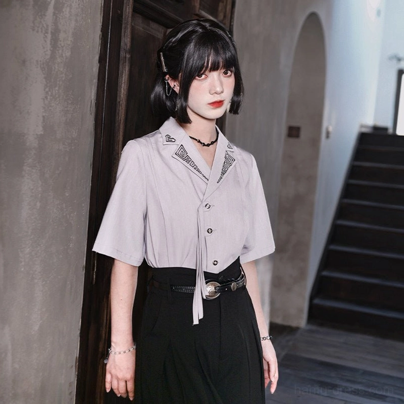 Light gray modern Chinese style Hanfu shirt with matching lapel embroidery and front tie styled with a black belt and pleated midi skirt
