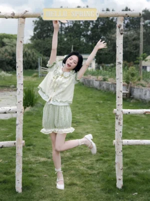 Full front view of a light green Chinese-inspired summer Hanfu outfit with puff sleeves, ruffled bloomers, and sweet Lolita styling on a sunny lawn