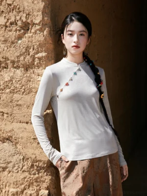 Light grey women’s modern Hanfu satin top with glossy shimmer fabric, slim long sleeves, diagonal decorative buttons, and jacquard wide-leg trousers