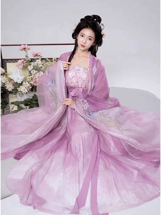 Light purple Tang Dynasty Hanfu Heziqun outfit shown in a seated view with wide flowing embroidered outer robe, soft gradient fabric, and matching waist sash