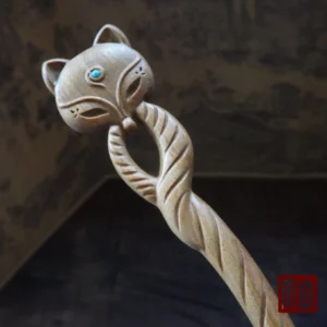Light wood Qingqiu fox Chinese hair stick close-up showing the twisted carved wooden shaft, detailed fox face, and turquoise eye inlay